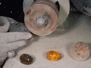 A jeweler shaves off the crust of amber with an emery wheel, Photograph by Paul Zahl, National Geographic, "Beach Awash in Amber"